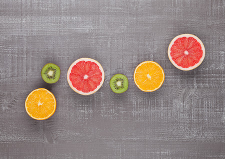 Fruits mix grapefruit orange and kiwi on wooden backgroundの写真素材