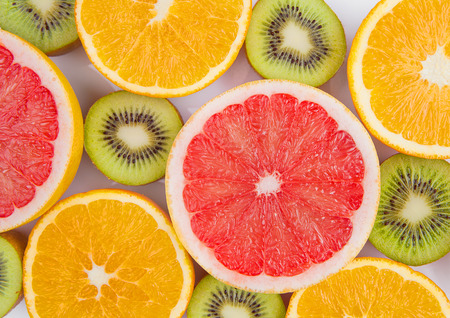 Fruits mix grapefruit orange and kiwi close up on whiteの写真素材