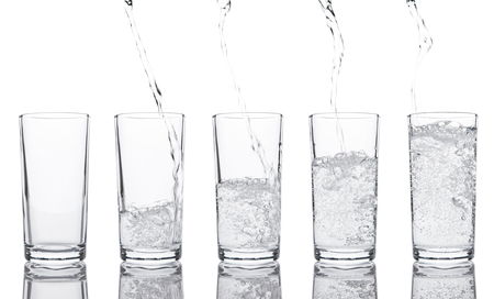 Pouring fresh healthy sparkling water to glass on white backgroundの写真素材