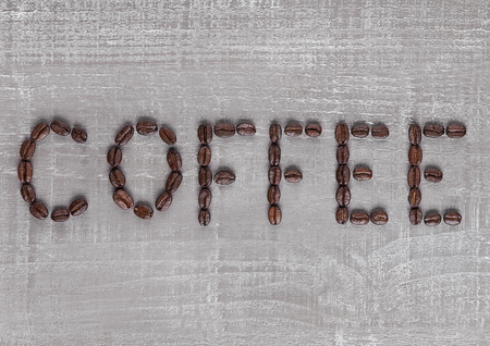 Coffee letters sign made from fresh coffee beans on wooden background for cafeの写真素材