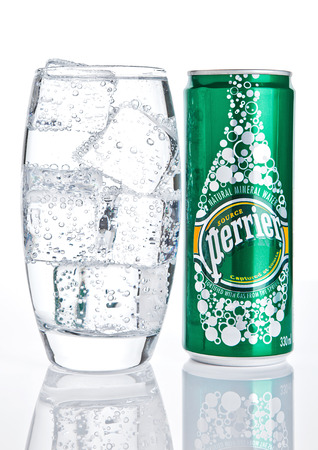 LONDON, UK - DECEMBER 06, 2016: Glass with ice and tin of Perrier sparkling water. Perrier is a French brand of natural bottled mineral water sold worldwide.のeditorial素材