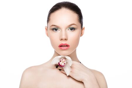 Beauty fashion model holding white orchid at spa on white backgroundの写真素材