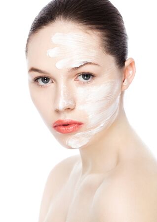 Beautiful woman girl with face cream natural makeup portrait on white backgroundの写真素材