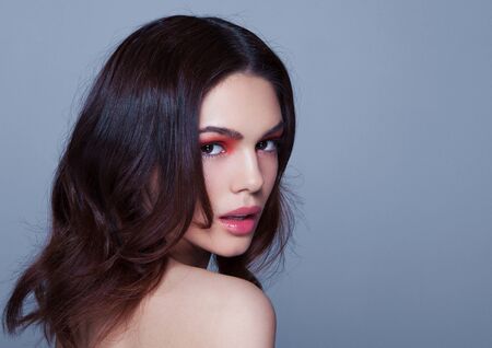 Beauty red eyes and lips makeup fashion model on grey background in cold tonesの写真素材
