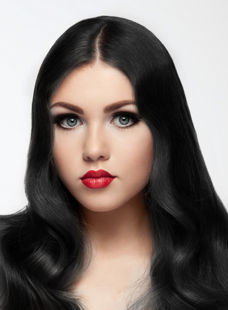 Beautiful brunette model with long hair and red lips on white background. Beauty portraitの写真素材