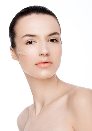 Beauty fashion model woman with liquid foundationon her cheek on white backgroundの写真素材