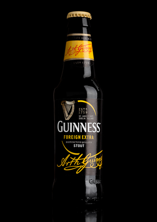 LONDON,UK - MARCH 21, 2017 : Bottle of Guinness foreign extra beer on black background.Guinness beer has been produced since 1759 in Dublin, Ireland.のeditorial素材