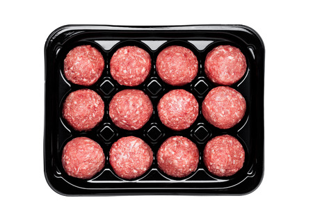 Raw beef meatballs in black plastick tray isolated on white backgroundの写真素材