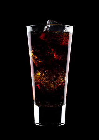 Glass of cold cola soda drink with ice cubes on black backgroundの写真素材