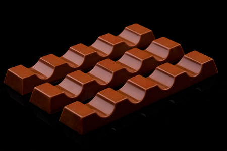Milk chocolate sweet bars on black background