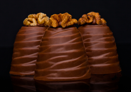 Luxury elegant milk chocolate candy with walnut on black background