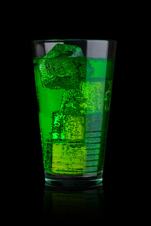 Glass of blue energy carbonated  soda drink with ice on black backgroundの写真素材