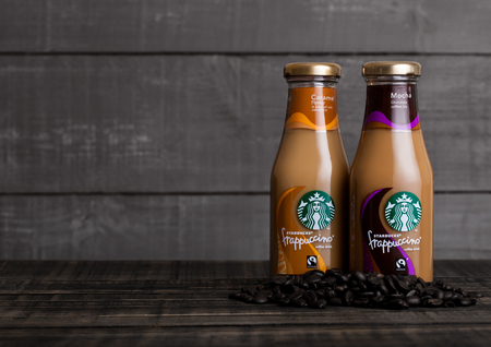 LONDON, UK -DECEMBER 15, 2017: Glass bottles of Starbucks frappuccino coffee drink with caramel on wooden background. Seattle based Starbucks is the largest coffeehouse company in the world.のeditorial素材