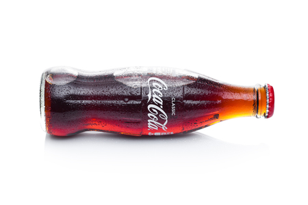 LONDON, UK - JANUARY 20, 2018: Cold glass bottle of Coca Cola drink on white background. The drink is produced and manufactured by The Coca-Cola Company.のeditorial素材