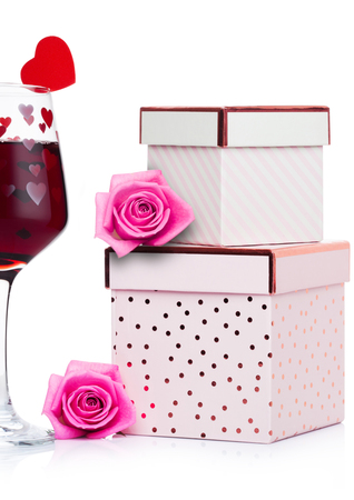 Glass of red wine with heart and pink gift box and rose for valentine's day on white backgroundの写真素材