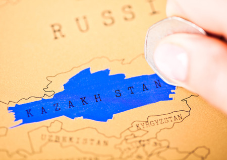 Travel holiday to Kazakhstan concept female hand coin choosing Kazakhstan 