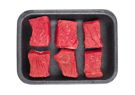 Pieces of fresh raw beef meat in plastic tray on white backgroundの写真素材