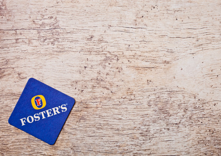 LONDON, UK - MARCH 22, 2018: Foster's crafted beer original beermat coaster on wooden background