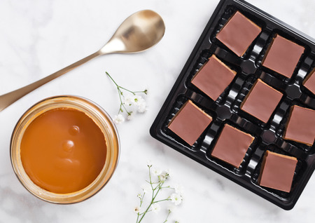 Caramel and biscuit shortcake bites dessert tray on marble board with jar of salted caramel and golden spoonの写真素材
