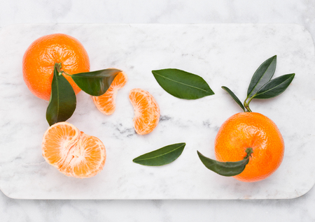 Fresh raw mandarin tangerines fruit with leaves on marble backgroundの写真素材