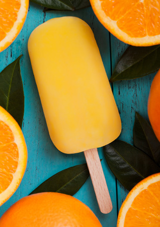 Fresh organic fruit orange ice cream with leaves with fresh oranges on blue wooden background.の写真素材