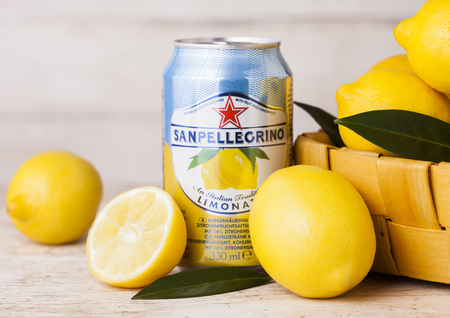 LONDON, UK - APRIL 27, 2018: Aluminium can of San Pellegrino sparkling lemon soda drink on wooden background with fresh lemons in bamboo basket.のeditorial素材