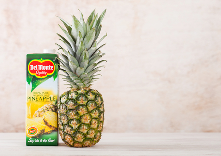 LONDON, UK - JUNE 30, 2018: Pack of Del Monte pineapple juice on wooden background with glass and raw fresh pineapple.のeditorial素材
