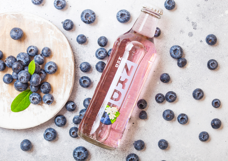 LONDON, UK - SPETEMBER 27, 2018: Glass bottle of NKD alcoholic cocktail drink on wooden background blueberry taste. Top viewのeditorial素材