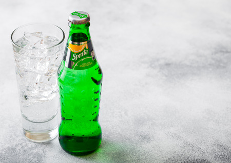 LONDON, UK - SEPTEMBER 28, 2018: Glass and bottle of Sprite soda drink with ice cubes and bubbles on stone kitchen table background.のeditorial素材