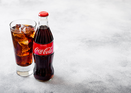 LONDON, UK - SEPTEMBER 28, 2018: Glass and bottle of Coca Cola soda drink with ice cubes and bubbles on stone kitchen background.のeditorial素材