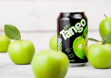 LONDON, UK - SEPTEMBER 13, 2018: Aluminium can of Tango drink with apple flavour with green apples on woodのeditorial素材
