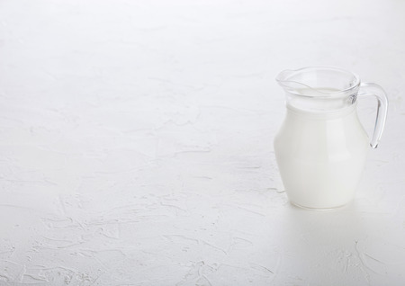 Glass jar of milk on white stone kitchen table background.の写真素材