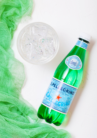 LONDON,UK - OCTOBER 10, 2018 : Bottle of San Pellegrino mineral water with glass and grren cloth on...