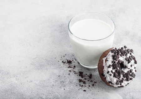Glass of milk and doughnut with black cookies on stone kitchen table background. の写真素材