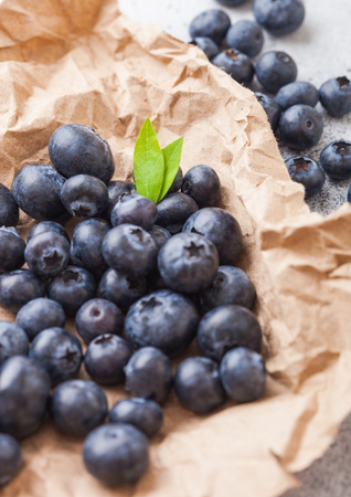 Fresh raw organic blueberries on brown paper on stone kitchen background. Space for textの写真素材