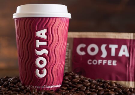 LONDON, UK - JUNE 05, 2019: Costa Coffee Paper Cup with pack of Original Costa Coffee with beans on wood.のeditorial素材