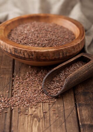 Raw natural organic linseed flax-seed in wooden bowl with spoon on wood background. Healthy omega 3 product.の写真素材