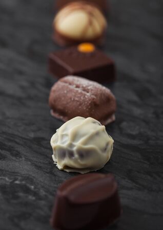 Luxury Chocolate candies selection on black marbel board. White, dark and milk chocolate assortment. Macroの写真素材