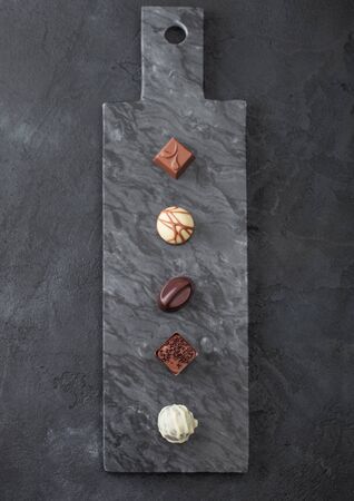 Luxury Chocolate candies selection on black marbel board. White, dark and milk chocolate assortment. Top viewの写真素材