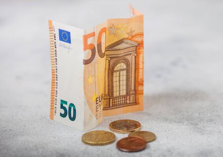 Fifty euro banknote with coins on light background. World economy crisis concept.