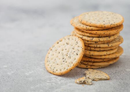 Stack of various organic crispy wheat flatbread crackers with sesame and salt on light background.の写真素材