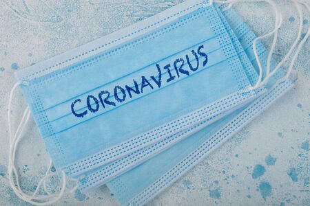 Medical face mask with coronavirus written on it on blue. Best protection from coronavirus, germs,bacteria and viruses. For hospital and every day use.の写真素材