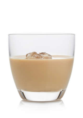 Glass with ice cubes of  whiskey and cream based liqueur on white background.