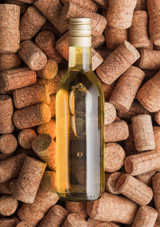Bottle of white wine on top of various wine corks background. Macroの写真素材