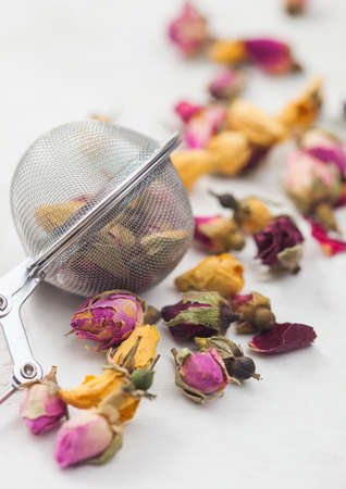 Rose buds mix tea with strainer infuser on white background. Macroの写真素材