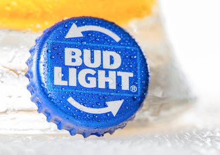 LONDON, UK - DECEMBER 22, 2022: Bud Light lager beer bottle cap with dew and cold glass on white.のeditorial素材