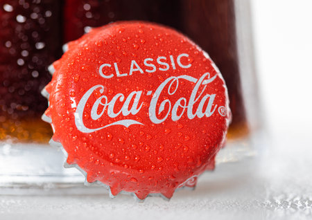 LONDON, UK - DECEMBER 22, 2022: Coca Cola Classic bottle cap with dew and cold glass on white.のeditorial素材