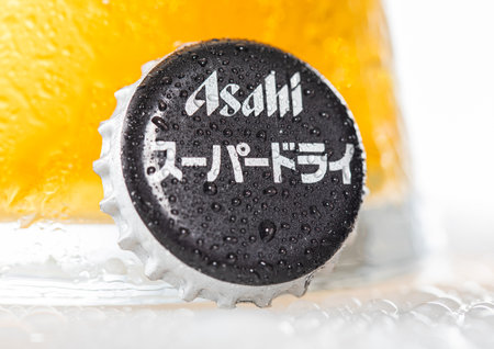 LONDON, UK - DECEMBER 22, 2022: Asahi super dry beer bottle cap with dew and cold glass on white.のeditorial素材