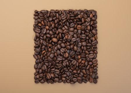 Square of fresh raw coffee beans on beige background.Top view.の写真素材