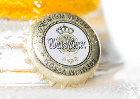 LONDON, UK - DECEMBER 12, 2022: Warsteiner lager beer bottle cap with dew and cold glass on white.のeditorial素材
